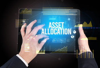 Close-up of hands holding tablet with ASSET ALLOCATION inscription, modern business concept