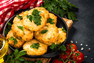 Chicken cutlet at dark table.