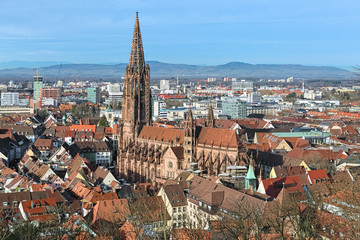 Obraz premium Freiburg im Breisgau, Germany. View over Freiburg Minster from slope of Schlossberg Hill. The cathedral was founded around 1200 and completed in 1330. It has remained largely intact in World War II.