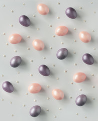 Pink and purple pearl Easter eggs and white pearls on a white background flatlay