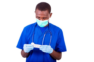 portrait of a young doctor holding a pack of tablets.