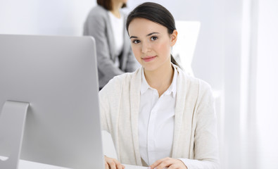 Casual dressed business woman working with computer in office. Lawyer or accountant at work