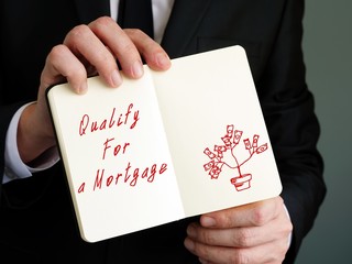 Qualify For A Mortgage phrase on the piece of paper.