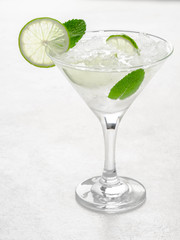 Mojito in a martini glass on a light background stands on the table