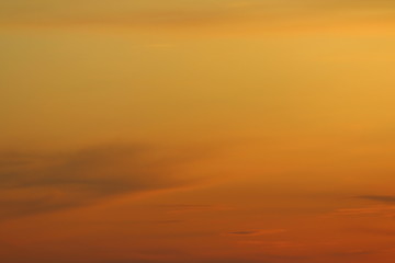 Sun below the horizon and clouds in the fiery dramatic orange sky at sunset or dawn backlit by the sun. Place for text and design.