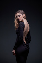 Girl in a black dress. Girl in a dress with an open back.
