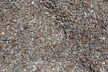 Natural background with fine brown and gray pebbles on the beach.
