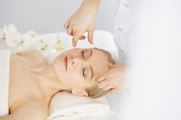 Fototapeta na wymiar Beautiful caucasian woman getting face depilation procedure. Beauty and Spa salon concept