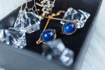 This is our own handmade earring.  Blue round beads, stones similar to sapphire, beautiful texture.  Withered plants and transparent ice cubes are good decorations for photography.  White plush blanke