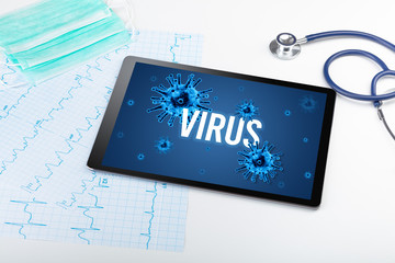 Tablet pc and doctor tools on white surface with VIRUS inscription, pandemic concept