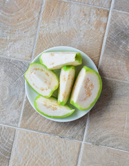 green round sliced ​​guava on a white plate