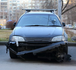 Dark right-hand drive car with a broken bumper