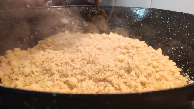 Spanish woman cooking migas at home, a traditional meal from Spain made with bread crumbs and chorizo sausage