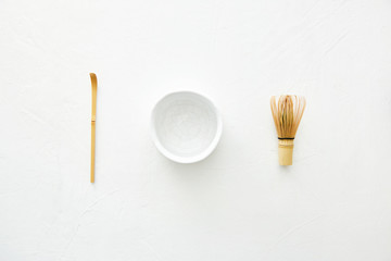
Chawan bowl, bamboo whisk and chashaku bamboo spoon on a white background. Top view.