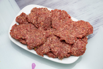 Female hands prepare meatballs on the wooden table