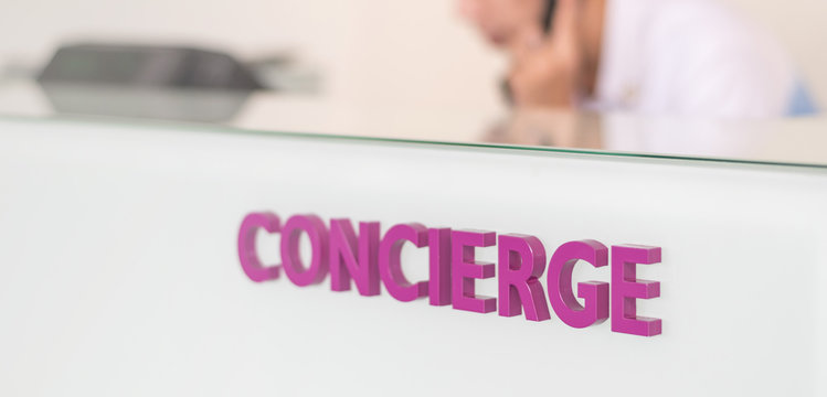 Concierge service desk counter with staff team working in front of hotel on phone with tourist business customer.