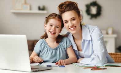 Fototapeta na wymiar Happy girl with mother studying online at home.