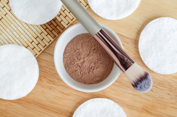 Pink bentonite clay powder in the bowl and make-up brush. Clay texture close up. Diy facial or hair mask, dry shampoo and body wrap recipe. Natural beauty treatment and spa. Top view, copy space