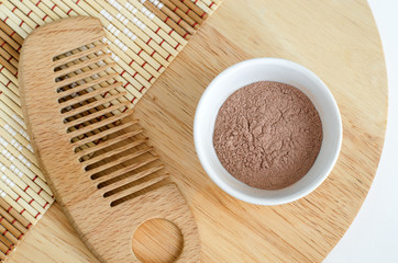 Pink bentonite clay powder in the bowl and hair brush. Clay texture close up. Diy facial or hair mask, dry shampoo and body wrap recipe. Natural beauty treatment and spa. Top view, copy space