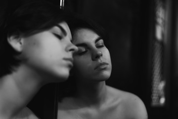 Sexy woman in a red skirt posing outdoors in the park.A bitchy girl smokes a cigarette and catches her eye.Beautiful model in various poses. Summer nature,all in green and red colors.Glasses on a girl