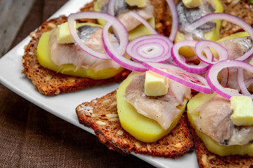 Open sandwich with herring, onion, potato and butter