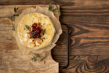 Baked camembert cheese, wooden background, copy space, top view