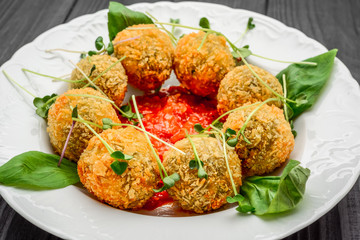 fried meat balls with vegetables and sauce on a plate