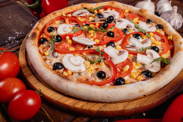 Pizza with sliced vegetables on rustic wood, vintage style