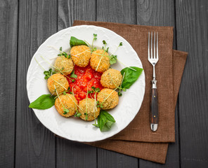 fried meat balls with vegetables and sauce on a plate