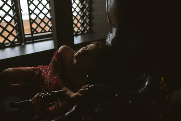 Sexy woman in a red skirt posing outdoors in the park.A bitchy girl smokes a cigarette and catches her eye.Beautiful model in various poses. Summer nature,all in green and red colors.Glasses on a girl