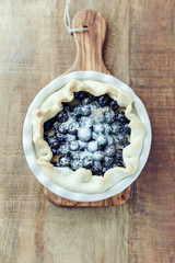 Blueberry Quiche ina Ceramic Dish on rustic wooden background. Top view. Copy space. 