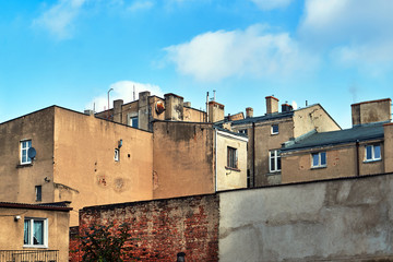 Fototapeta na wymiar Chimneys and walls of marked residential houses in the city of Gniezno in Poland.