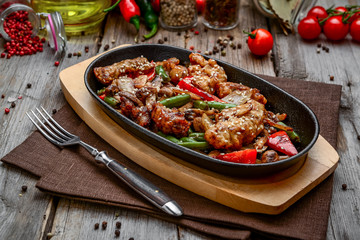 fried meat with vegetables in a pan