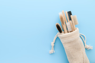 Zero waste concept. Set of eco natural bamboo toothbrushes in a cotton bag on a light blue background. Top view, copy space. Eco-friendly, without plastic.