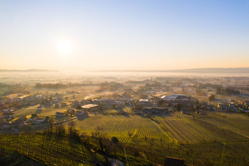 foggy morning on italian countryside plain  with houses and fields