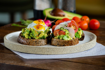 Avocado toast with radish, cherry tomatoes, black sesame seeds, and quail eggs