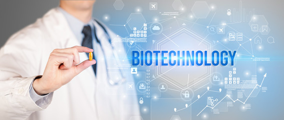 Doctor giving a pill with BIOTECHNOLOGY inscription, new technology solution concept