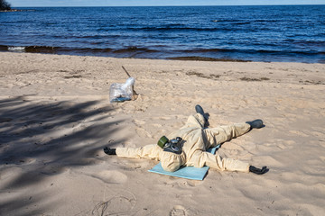man in protective suit, mask on sand