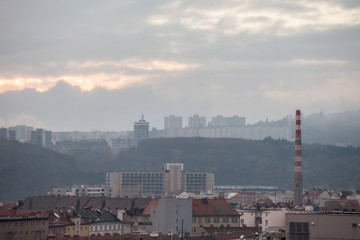 Obraz premium Panorama czeskich brutalistycznych budynków, zwanych Panelaky, na przedmieściach Brna w Czechach, ze starymi budynkami przemysłowymi z kominem fabrycznym. Są symbolami komunistycznej architektury