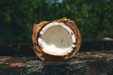 Broken coconuts on a wooden table with palm leaves