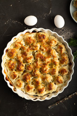 Close-up top view of a frying pan with chicken meatballs, eggs and scattered pepper