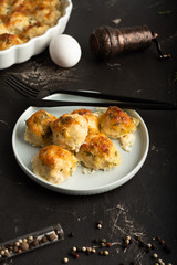 Table with meatballs in sour cream sauce, cutlery, scattered pepper, egg and frying pan