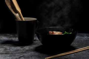Yellow noodles with white smoke on a dark background