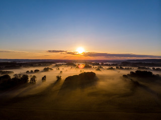 Wonderful sunrise over fields in the fog