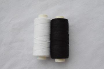 Fototapeta na wymiar Reels of black and white thread on a white background.