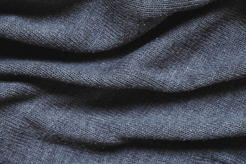 Texture of gray knitted material as background image. Knitting on the knitting needles. Top view. Copy, empty space for text