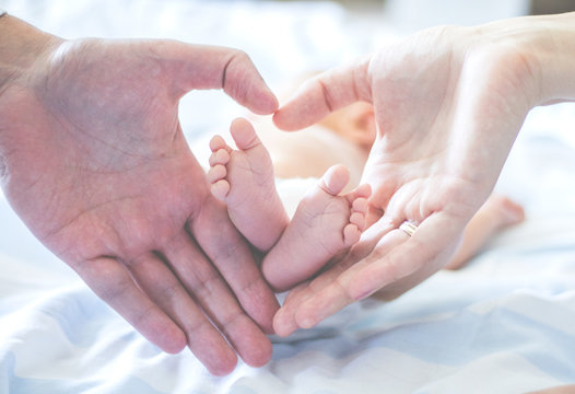 Cropped Hands Of Couple With Baby At Home
