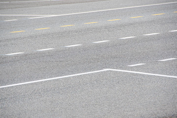 grey asphalt road with markings for drivers, traveling by car