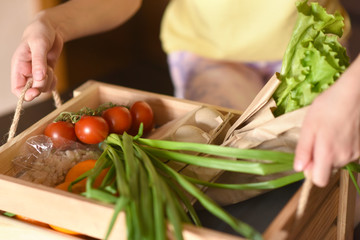 little girl with laptop. young woman holding blank sign. Coronavirus. Woman with face mask on quarantine, cooks in the kitchen at home during coronavirus crisis. Stay at home. Enjoy cooking at home. F