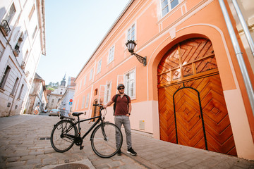 Fototapeta premium Handsome young caucasian cyclist standing in front of house